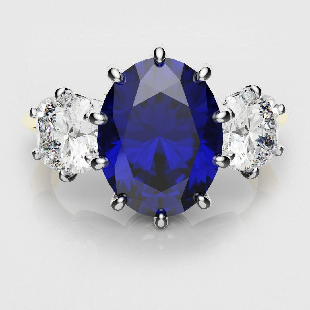 ceylon blue ovak sapphire trilogy engagement ring with cushion cut shoulder diamonds. Platinum securing the diamonds and an 18ct yellow gold shank