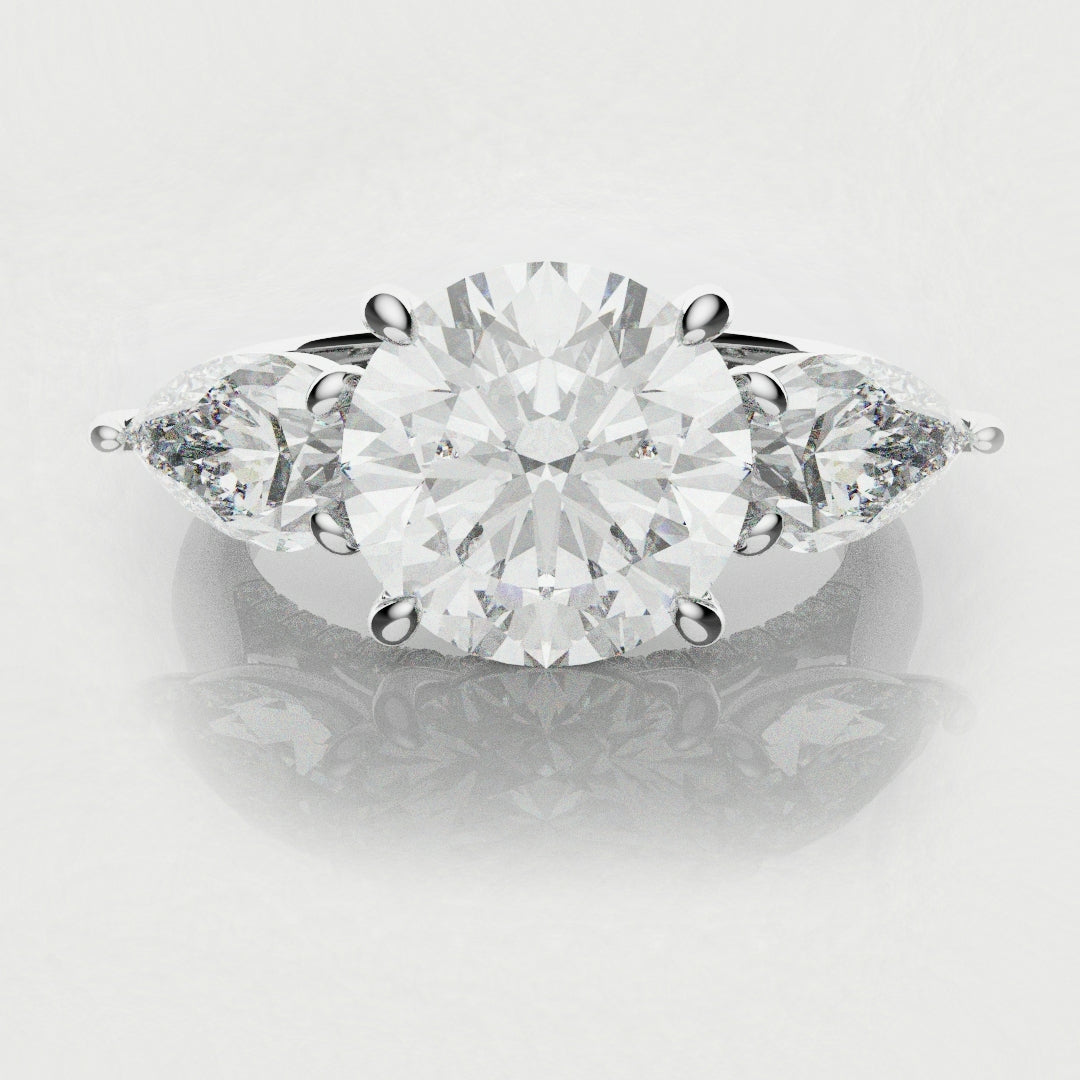 three stone round and pear diamond engagement ring