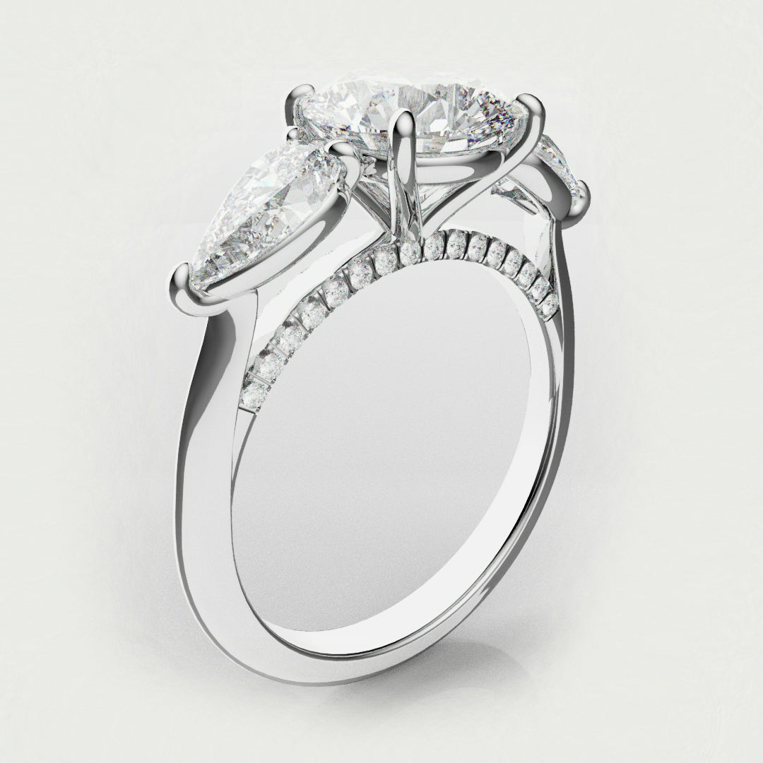 round and pear diamond three stone engagement ring