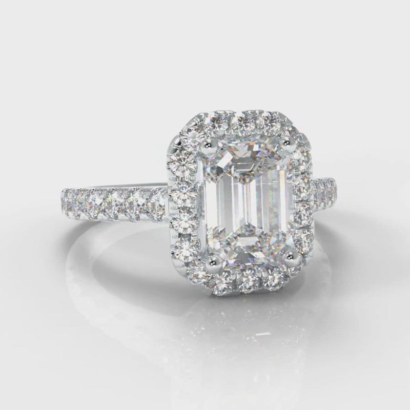 Halo engagement ring set with an emerald cut diamond centre stone, encircled by a glistening diamond halo
