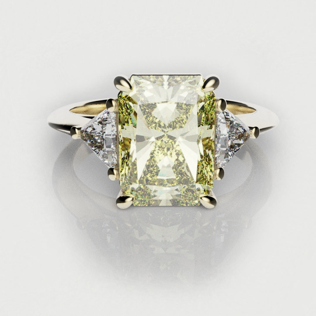 yellow diamond trilogy engagement ring with radiant cut center diamond and trilliant shoulder diamonds on an elegant 18ct yellow gold band