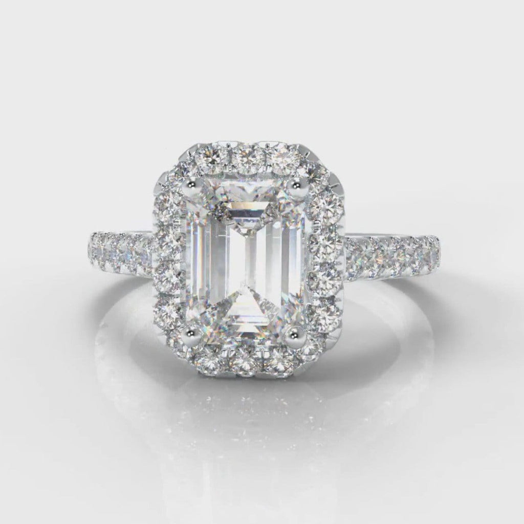 Halo engagement ring set with an emerald cut diamond centre stone, encircled by a glistening diamond halo